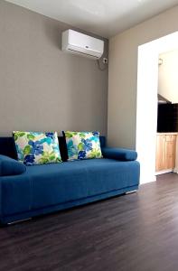 - un canapé bleu avec deux oreillers dans le salon dans l'établissement Просторная квартира студия ЮЖД 5 минут, à Kharkov