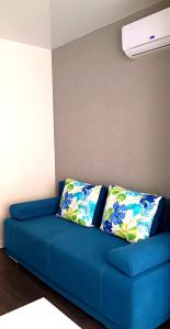 - un canapé bleu avec deux oreillers dans l'établissement Просторная квартира студия ЮЖД 5 минут, à Kharkov