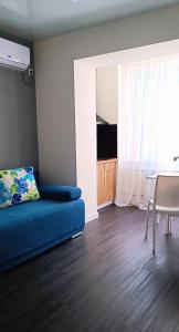 - un salon avec un lit bleu et une table dans l'établissement Просторная квартира студия ЮЖД 5 минут, à Kharkov