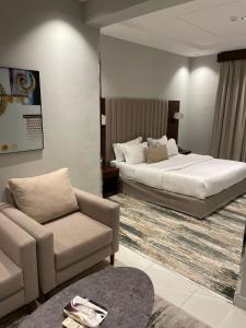 1 dormitorio con 1 cama, 1 sofá y 1 silla en شقق البندقية للوحدات الفندقية ALBUNDUQI HOTEl, en Riad