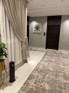 un couloir avec une porte et un rideau dans l'établissement شقق البندقية للوحدات الفندقية ALBUNDUQI HOTEl, à Riyad
