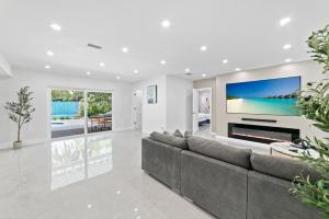 a living room with a large couch and a tv at Ultimate Vacation Retreat heated pool & Mini Golf L63 in Hialeah