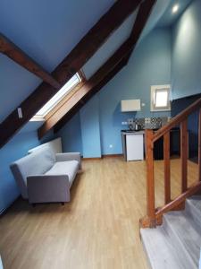 een zolderwoonkamer met een bank en een tafel bij Bleu studio appart in Sevran