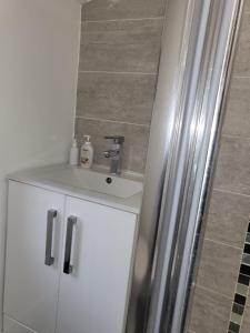 a bathroom with a sink and a white cabinet at Affordable rooms in Gillingham in Gillingham