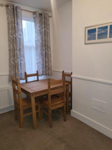 un tavolo in legno con sedie in una stanza con finestra di Affordable rooms in Gillingham a Gillingham