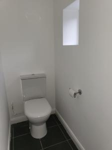 a bathroom with a toilet and a roll of toilet paper at Affordable rooms in Gillingham in Gillingham