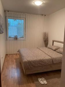 a bedroom with a bed and a window at Alacaster in Novi Sad