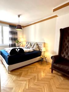 a bedroom with a bed and a couch and a chair at Center Apartment with 360° Rooftop in Vienna