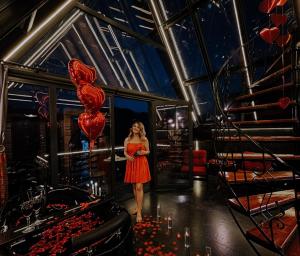 a woman standing in a room with a bunch of red balloons at RizeHayatburdabungalov in Ardeşen