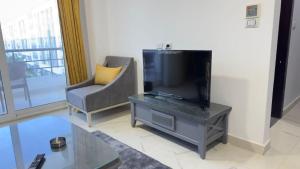 a living room with a flat screen tv and a chair at Direct Sea & Pool View FANADIR BAY in Hurghada