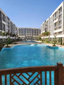 a large pool of blue water in front of buildings at Direct Sea & Pool View FANADIR BAY in Hurghada