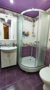 uma casa de banho com um chuveiro, um lavatório e um WC. em Apartment on Sportivnaya em Bender