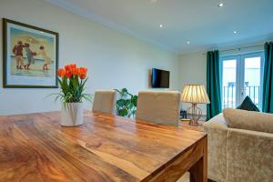 a living room with a wooden table with a vase of flowers at Inglewood Apartment, Ingleton, Yorkshire Dales National Park, Famous 3 Peaks and Near The Lake District Pet Friendly in Ingleton
