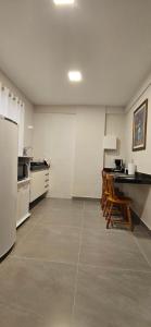 uma cozinha com um frigorífico, uma mesa e cadeiras em Kitnet Aconchego dos Nobres em Domingos Martins