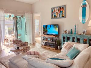 uma sala de estar com um sofá e uma televisão de ecrã plano em Coastal Cottage at Naples Bay em Naples