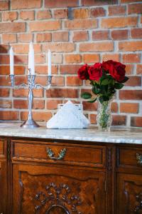 una mesa con dos velas y un jarrón de rosas en Pola Apartament Rodzinny, en Polanica-Zdrój