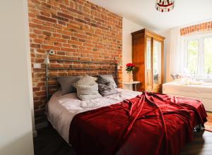 Un dormitorio con una pared de ladrillo y una cama grande en Pola Apartament Rodzinny, en Polanica-Zdrój