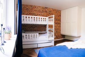 een slaapkamer met een bakstenen muur en een bed bij Pola Apartament Rodzinny in Polanica-Zdrój
