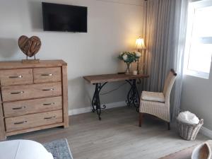 a bedroom with a dresser and a desk with a dresser and a dress at Ships Bell 17B in St Francis Bay