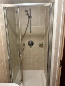 a shower with a glass door in a bathroom at Sultania Motel and Catering in Hedgerley
