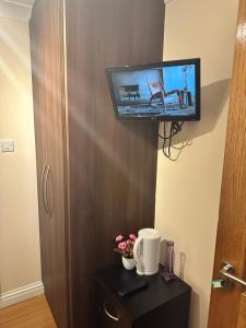 a flat screen tv on a wall next to a room at Sultania Motel and Catering in Hedgerley