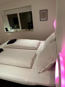 a bedroom with two beds with white sheets and a window at Luxury New Cozy and Quietly 95m2 in Tórshavn