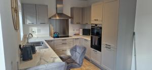 una cucina con armadi bianchi e ripiano in marmo di Brand new Entire 4-Bed House in Peterborough a Peterborough Altre 28 foto