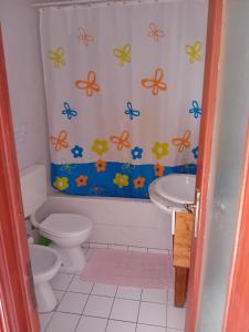 a bathroom with a toilet and a shower curtain with butterflies at T2 N16 Ref 006 in Tavira