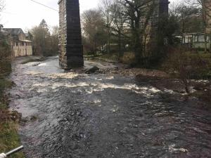 a flooded street with a brick chimney in a yard at Labernum Cottage, Ingleton, Yorkshire Dales National Park 3 Peaks and Near the Lake District, Pet Friendly in Ingleton