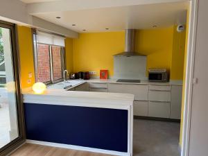 a kitchen with yellow walls and a blue counter top at O2 in Le Touquet-Paris-Plage