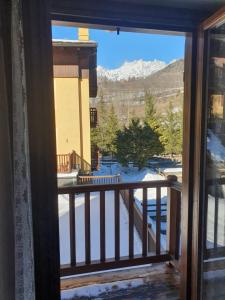 d'une fenêtre donnant sur un balcon enneigé. dans l'établissement PI.GI.'s apartment, à Pré-Saint-Didier