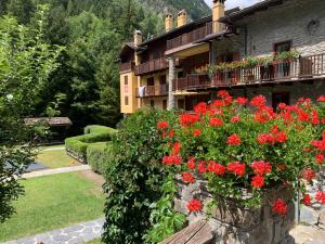 un bâtiment avec des fleurs rouges devant dans l'établissement PI.GI.'s apartment, à Pré-Saint-Didier