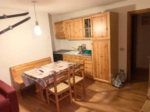 une cuisine avec une table et des armoires en bois dans l'établissement PI.GI.'s apartment, à Pré-Saint-Didier