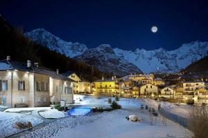 une ville sous la neige la nuit avec la lune dans l'établissement PI.GI.'s apartment, à Pré-Saint-Didier 13 autres photos