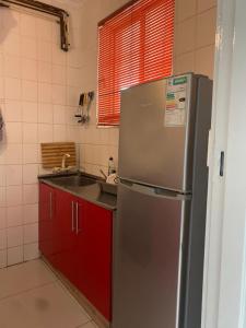 a kitchen with a stainless steel refrigerator and red cabinets at Amanzimtoti Afsaal Holiday Letting in Amanzimtoti