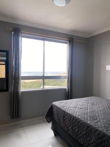 a bedroom with a bed and a large window at Amanzimtoti Afsaal Holiday Letting in Amanzimtoti