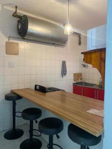 a kitchen with a wooden counter and stools at Amanzimtoti Afsaal Holiday Letting in Amanzimtoti