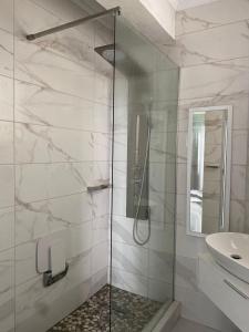 a white bathroom with a shower and a sink at Amanzimtoti Afsaal Holiday Letting in Amanzimtoti