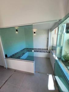 una piscina in un edificio con parete in vetro di CasaOka Paraibuna a Paraibuna