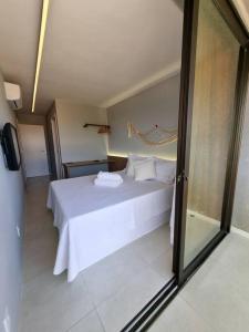 a bedroom with a bed with white sheets and pillows at Kanui Milagres 112 in São Miguel dos Milagres