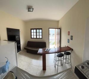 a living room with a table and a couch at Recanto da Gabi in Ubatuba