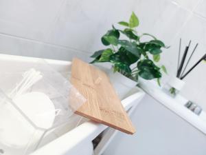 ein Holzschild auf einem weißen Tisch mit einer Pflanze in der Unterkunft CENTER Santa Cruz, Alojamiento céntrico con gran terraza, cocina , salón y baños, todo privado in Santa Cruz de Tenerife + 54 Fotos