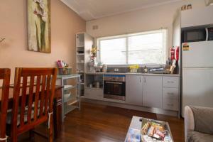 a kitchen with white cabinets and a white refrigerator at Kurranulla Sapphire - U2 in Cronulla