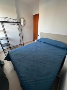 een slaapkamer met een bed met een blauw dekbed bij Apartamento LOLO in El Médano