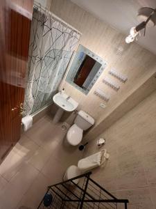 een badkamer met een wastafel, een toilet en een spiegel bij Apartamento LOLO in El Médano