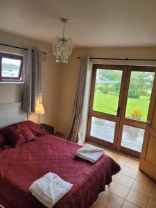 um quarto com uma cama e uma grande janela em Brigadoon lakeview room em Roundwood