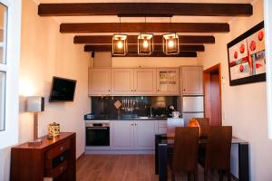 a kitchen with white cabinets and a dining table at Casinha do Sabugueiro in Ponte de Lima