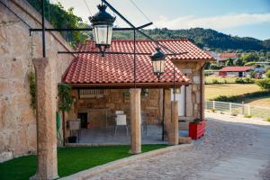 a building with a red roof and two lights at Casinha do Sabugueiro in Ponte de Lima