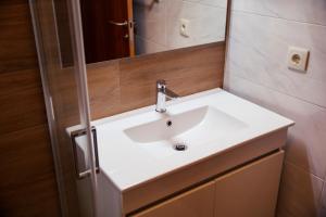 a bathroom with a white sink and a mirror at Casinha do Sabugueiro in Ponte de Lima