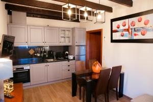 a kitchen with white cabinets and a dining table at Casinha do Sabugueiro in Ponte de Lima +8 photos